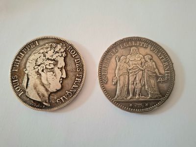 two silver coins, one of which has a bust and the other of which is a bust