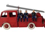 trois figurines de pompiers assis à l'arrière d'un camion de pompiers