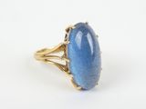 a gold ring with a blue stone in the center