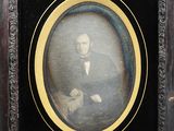 portrait of a man in a tuxedo and bow tie in a wooden frame