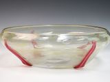 a glass bowl with a red handle on a white table