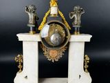 a white marble clock with a gold eagle on top of it
