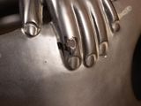 a metal sculpture of a hand holding a knife