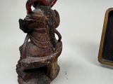 a small statue of a man sitting on a bench next to a picture frame