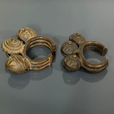 deux bijoux en or posés sur une table, avec un miroir en arrière-plan