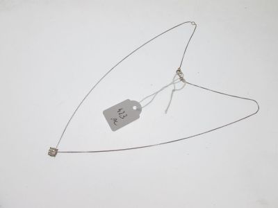 un collier auquel est attachée une étiquette sur une surface blanche