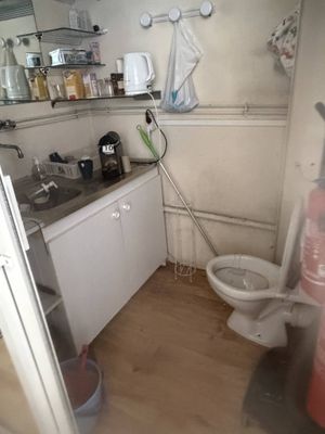 a bathroom with a toilet, sink, and other items in it