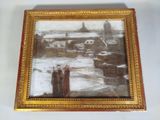 an old picture of two people standing in the snow in front of a building