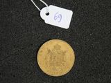 a gold coin on a black surface with a price tag on it