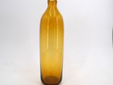 a yellow glass bottle that is sitting on a white surface