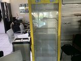a yellow refrigerator in the middle of a room with chairs and tables
