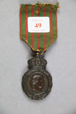 une image représentant une médaille entourée d'un ruban rouge et vert