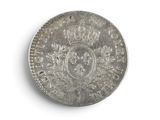 a silver coin with a crown on it on a white surface