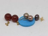 three pairs of earrings that are on a blue surface