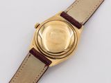 a close up of a gold watch with a brown leather strap