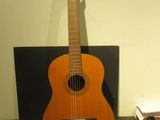 une guitare posée sur une étagère dans une pièce