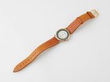 un gros plan d'une montre sur une surface blanche avec un fond blanc