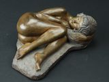 statue représentant une femme allongée sur un rocher, les mains sur le visage