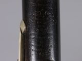 close up view of a flute with a black body and brass fittings
