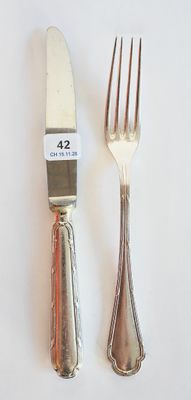 deux fourchettes et un couteau sur une table blanche