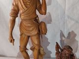 une statue représentant un homme tenant un bâton, à côté d'une statue représentant un chien