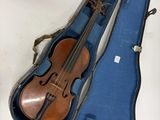un violon dans un étui bleu posé sur une surface blanche