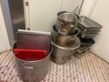 many pots and pans sitting on the floor next to each other