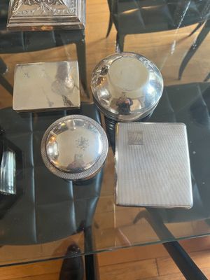 a glass table with silver dishes on it in a room