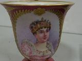 a vase with a picture of a woman in a crown on it