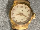a gold wrist watch with a blue strap on it