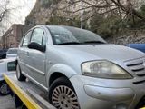 a silver car on a flatbed in a parking lot