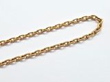 a close up of a gold chain on a white surface