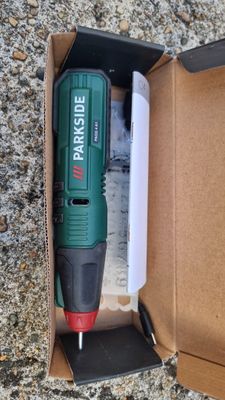 a box with a cordless drill in it on the ground