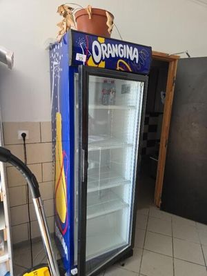 un réfrigérateur bleu sur lequel est accrochée une affiche, dans une cuisine