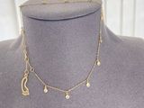 a close up of a mannequin with a gold necklace on a mannequin