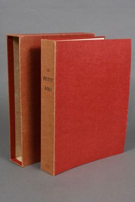 an open red book sitting on top of a table next to another book