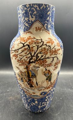 un vase bleu et blanc orné d'une image représentant un arbre