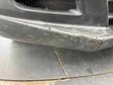 the front bumper of a car with rust on the side of it