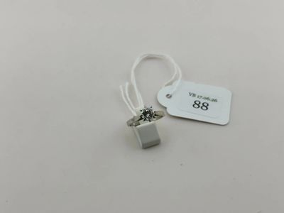 une étiquette blanche posée sur une table blanche, avec un petit objet argenté
