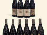 six bottles of wine are lined up on a white surface