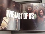 an open book with a picture of the last of us and a picture of a man holding a gun
