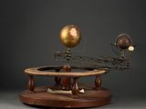 an image of a model of the solar system on a wooden stand