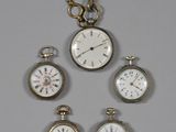 quatre types différents de montres de poche suspendues à une chaîne fixée au mur