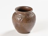 a small brown vase sitting on a white table