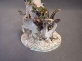 a figurine of a goat with grapes on its head