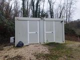 une photo de toilettes portables dans les bois