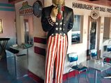 a statue of a man that is standing in front of a restaurant