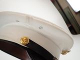 a white hat with a gold button on it