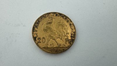 gros plan d'une pièce d'or sur une surface blanche