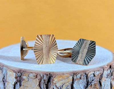 a close up of a pair of cuff rings on a tree stump